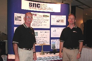 OKLAHOMA CITY—(l to r): Mr. Herman Adams, and Mr. Jeffrey Ellis, Sales Associates, Tactical Communications, Sierra Nevada Corporation, with their display at the July Technology Expo hosted by the Oklahoma City Chapter.